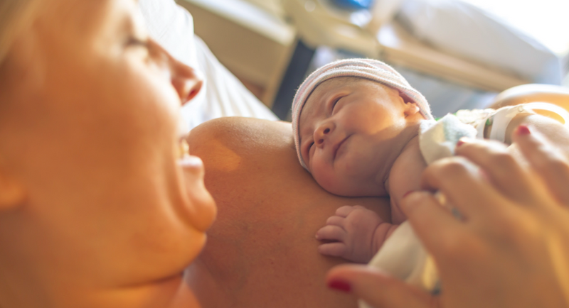 newborn baby on a womans chest 