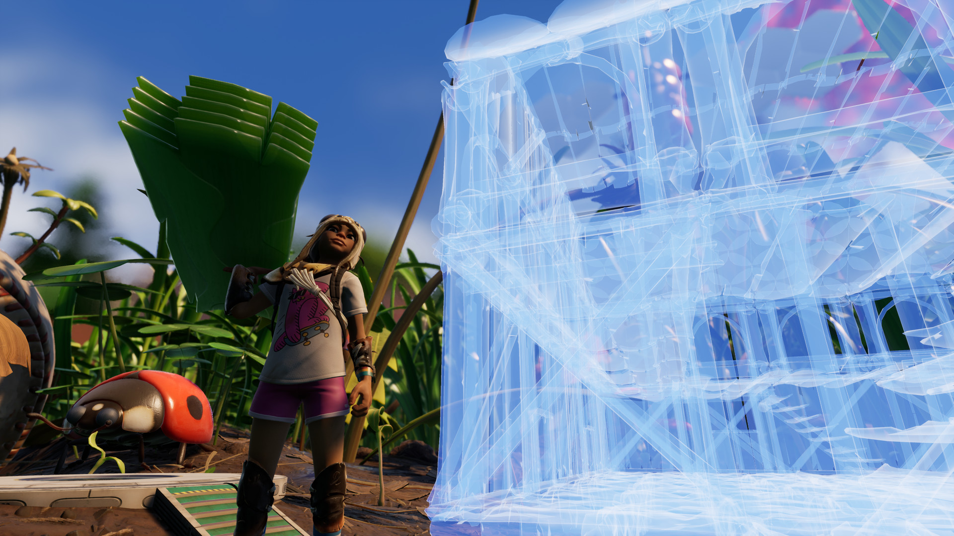 A player beside a large translucent blue construction built in the grass