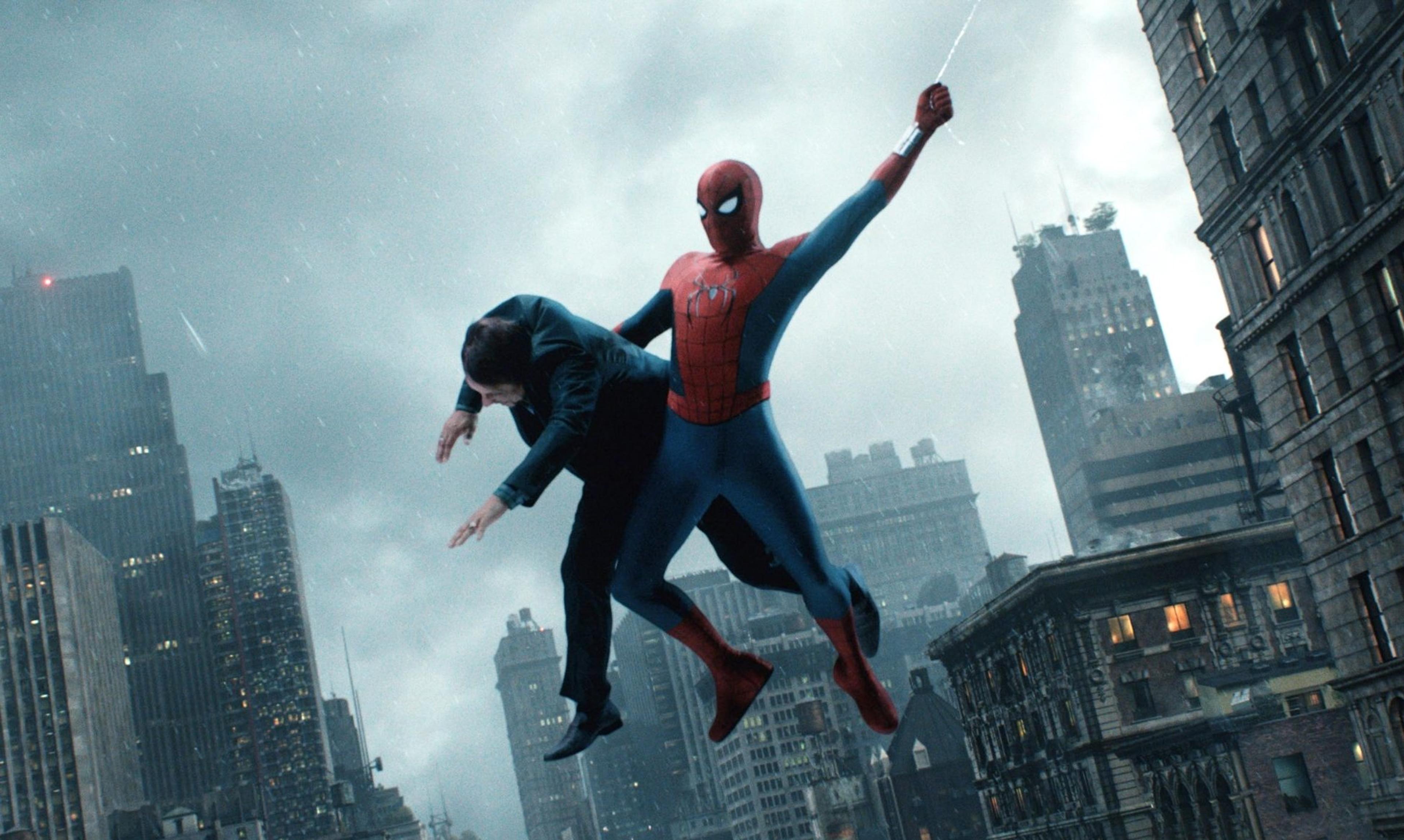 Spider-Man swinging through a rainy New York skyline carrying a man in a suit. Still from the Spider-Man: Brand New Day trailer via Sony Pictures.