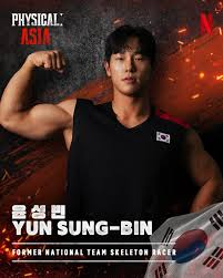 A Korean competitor in close-up flexing, national flag on his shirt