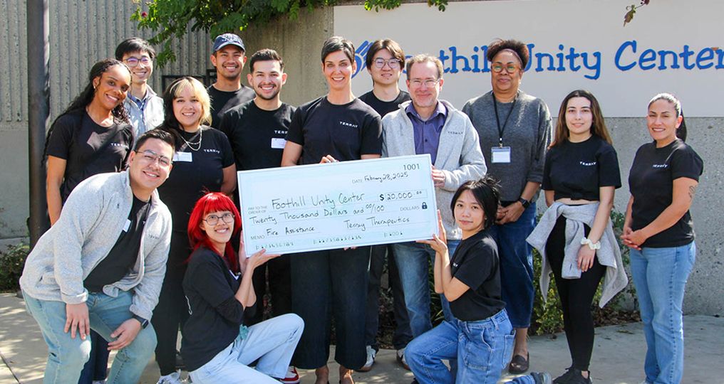 A group of people proudly holding an oversized check