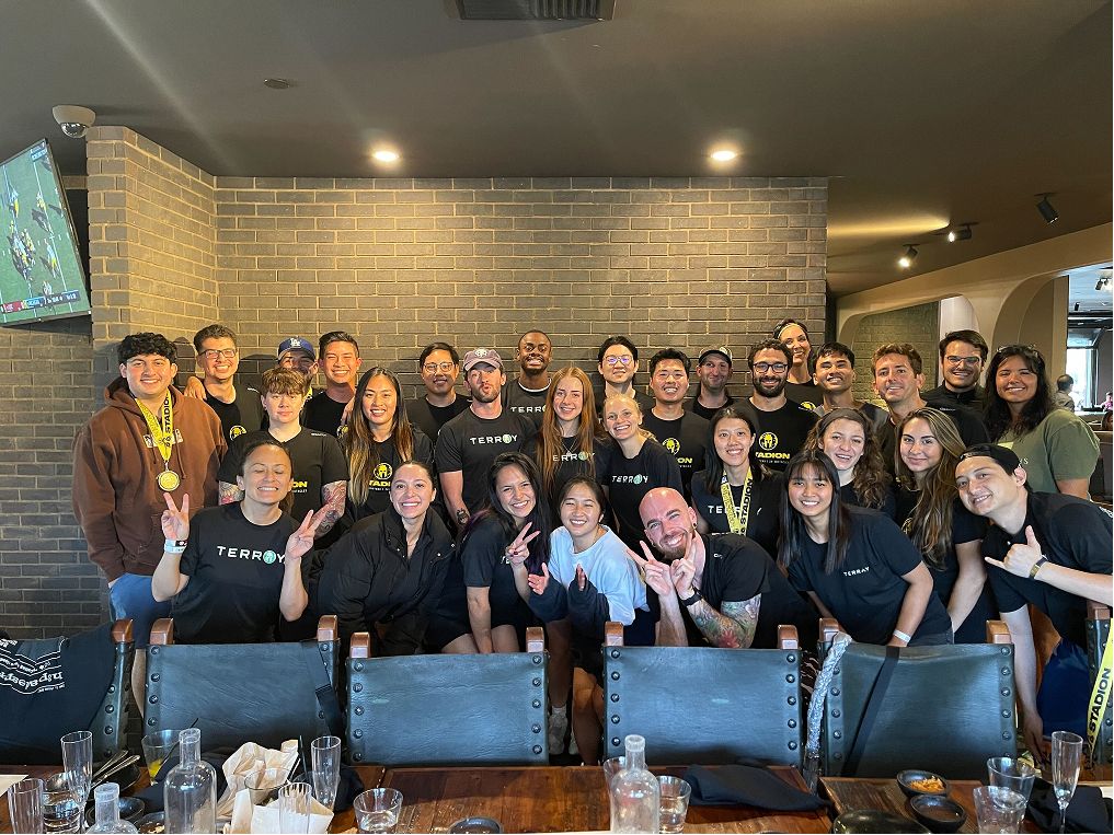 A large group of happy people in front of a brick wall