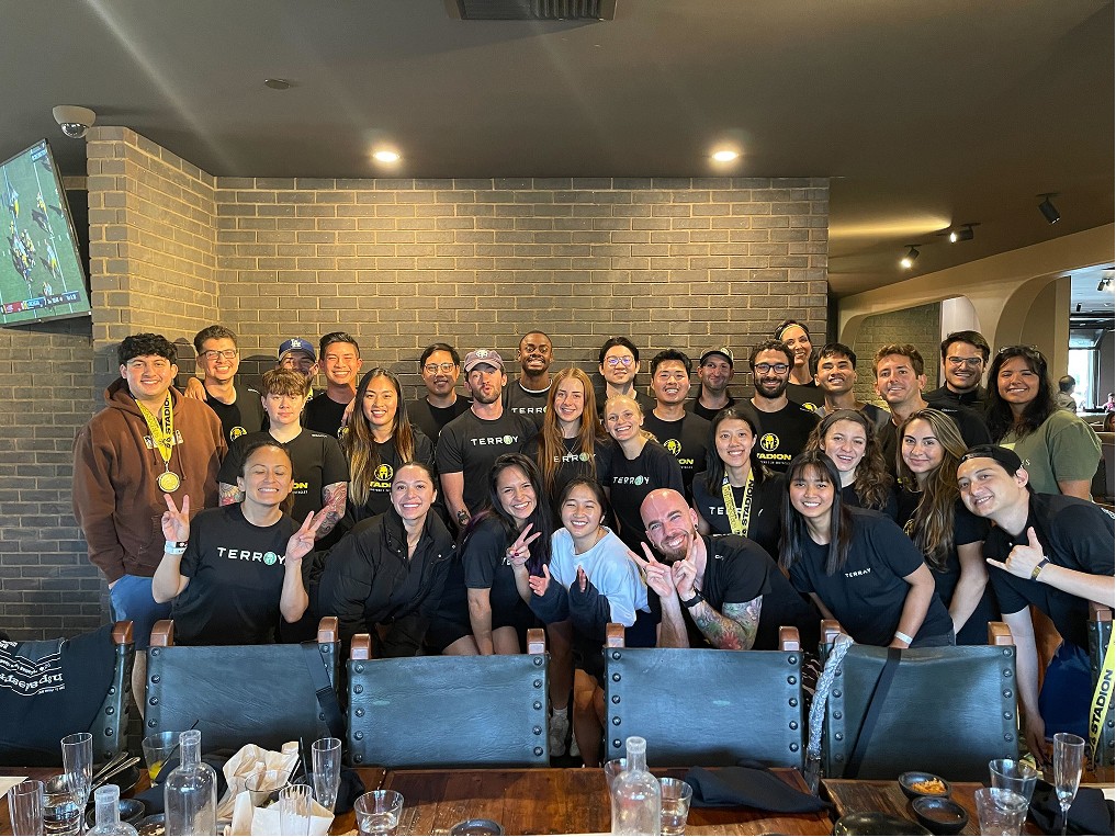 A large group of happy people in front of a brick wall