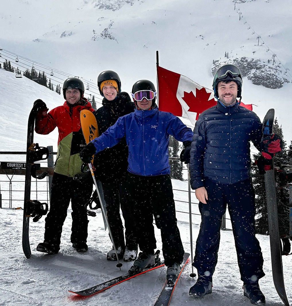 4 people in ski gear on a snowy mountain