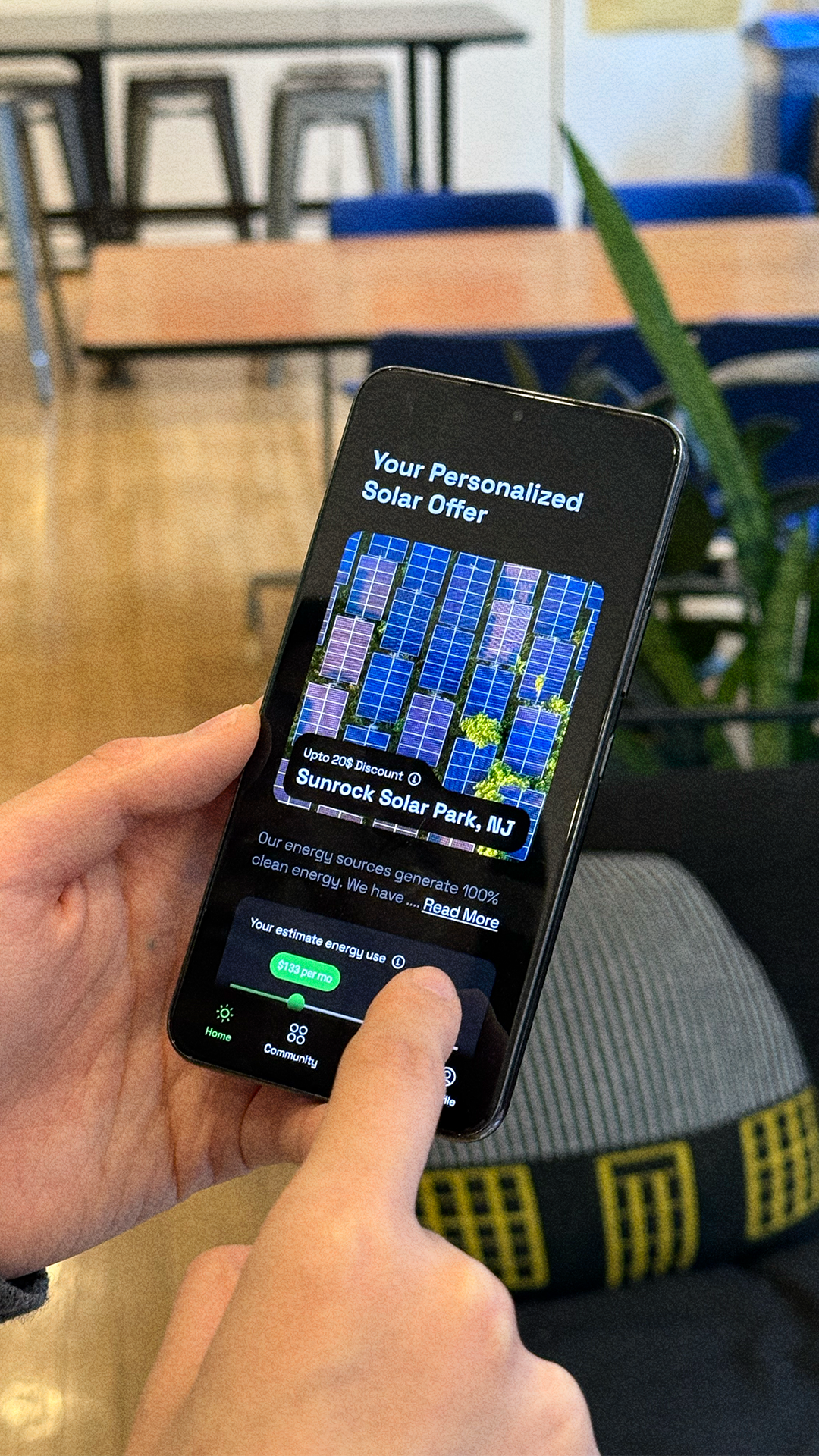 A person holds a smartphone displaying a personalized solar energy offer for Sunrock Solar Park in New Jersey, with an estimated monthly energy cost slider visible on the screen.