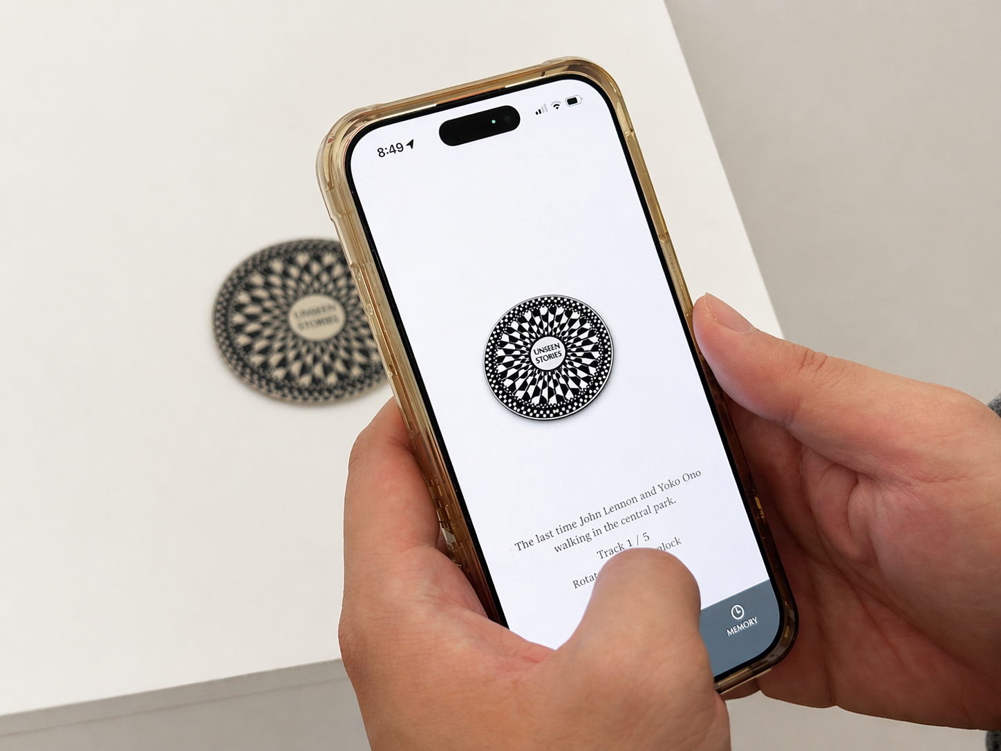 Hands holding a phone with an abstract black and white symbol containing the words 'Unseen Stories'. 