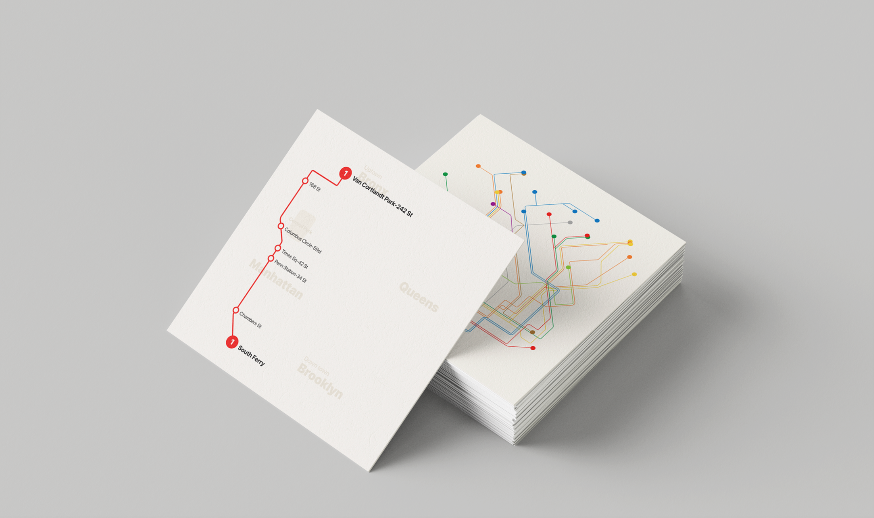A stack of printed transit map cards featuring a colorful subway network diagram and a simplified route map for the 1 train line.