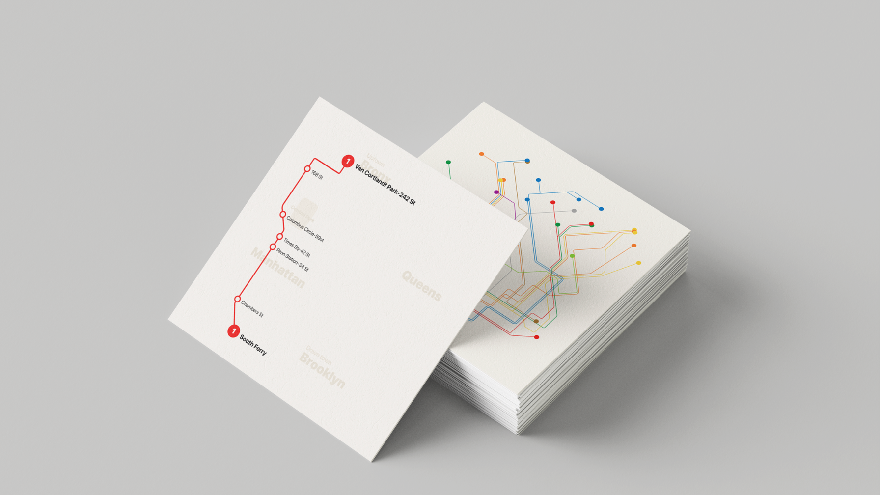 A stack of printed transit map cards featuring a colorful subway network diagram and a simplified route map for the 1 train line.
