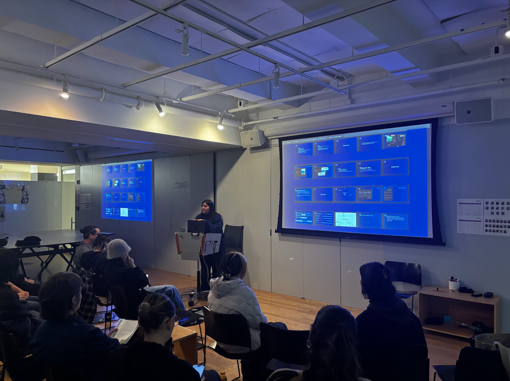 Student standing in front of a class, presenting her work.