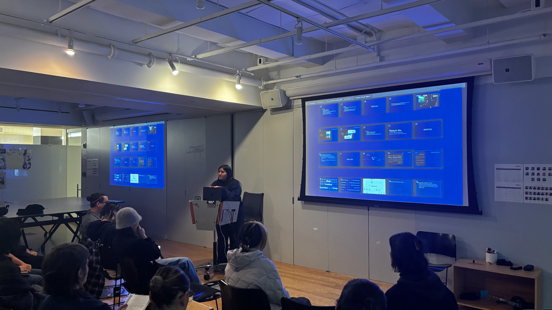 Student standing in front of a class, presenting her work.