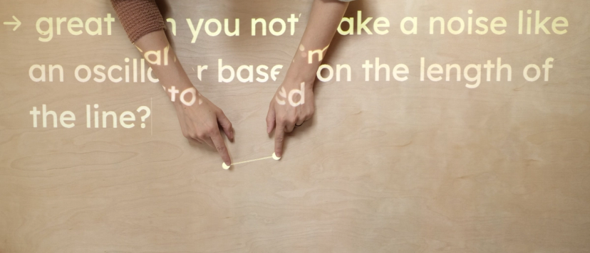 Image of hands activating a projection using Procession. Text projected over the hands reads: Can you make a noise like an oscillator based on the length of the line?