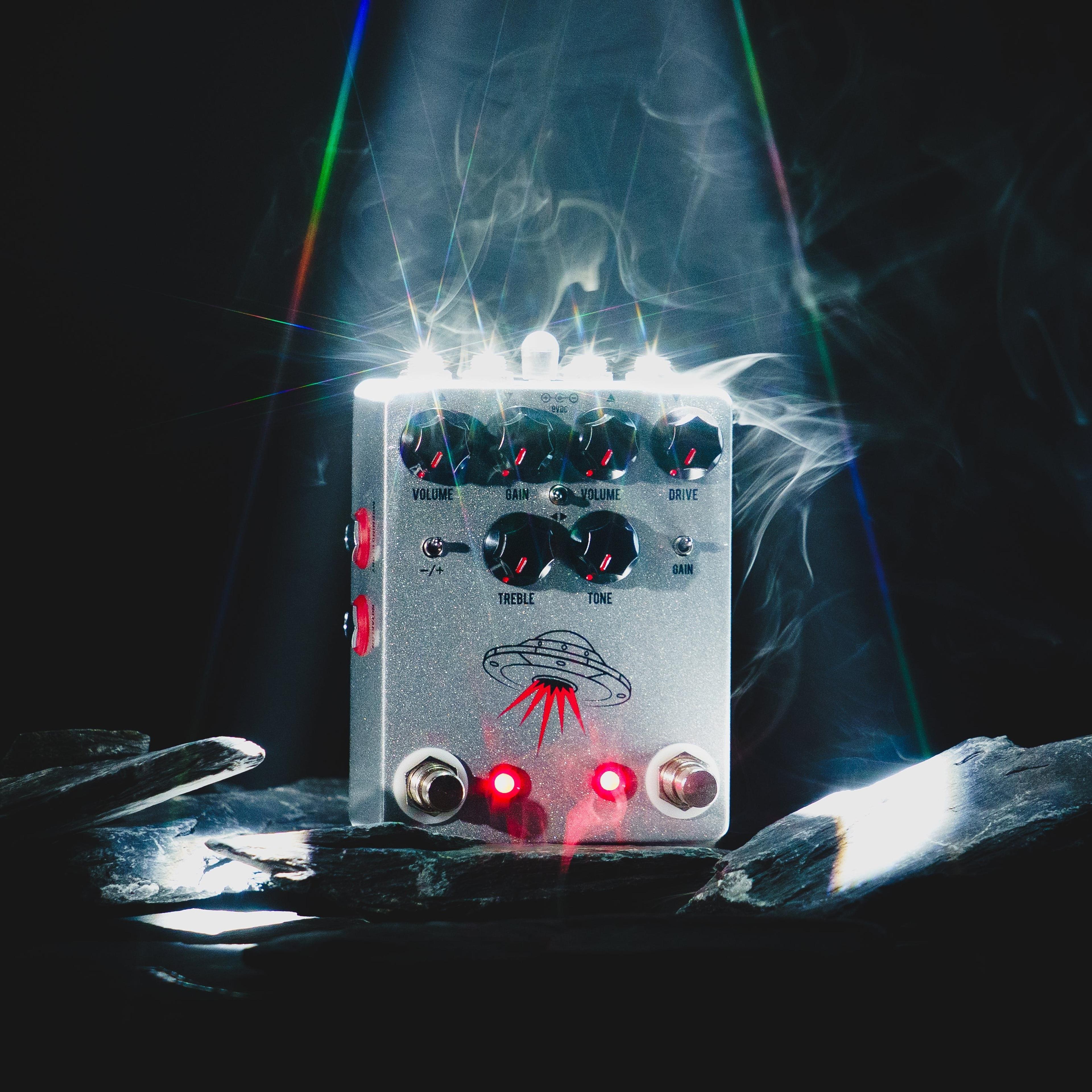 JHS Wanderer on dark slate under a white spotlight with drifting smoke, both LEDs lit red