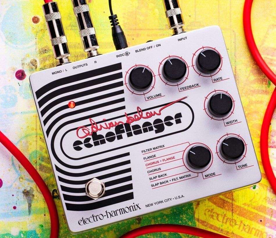 Electro-Harmonix Adrian Belew Echoflanger on a paint-splattered surface with red instrument cables plugged in