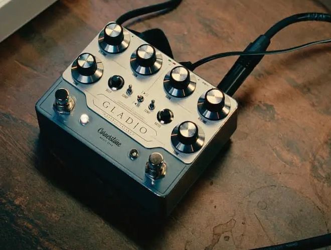 Cornerstone Gladio mk3 on a wooden desk with patch cables plugged in, Deep and Ratio knobs visible between the two channels