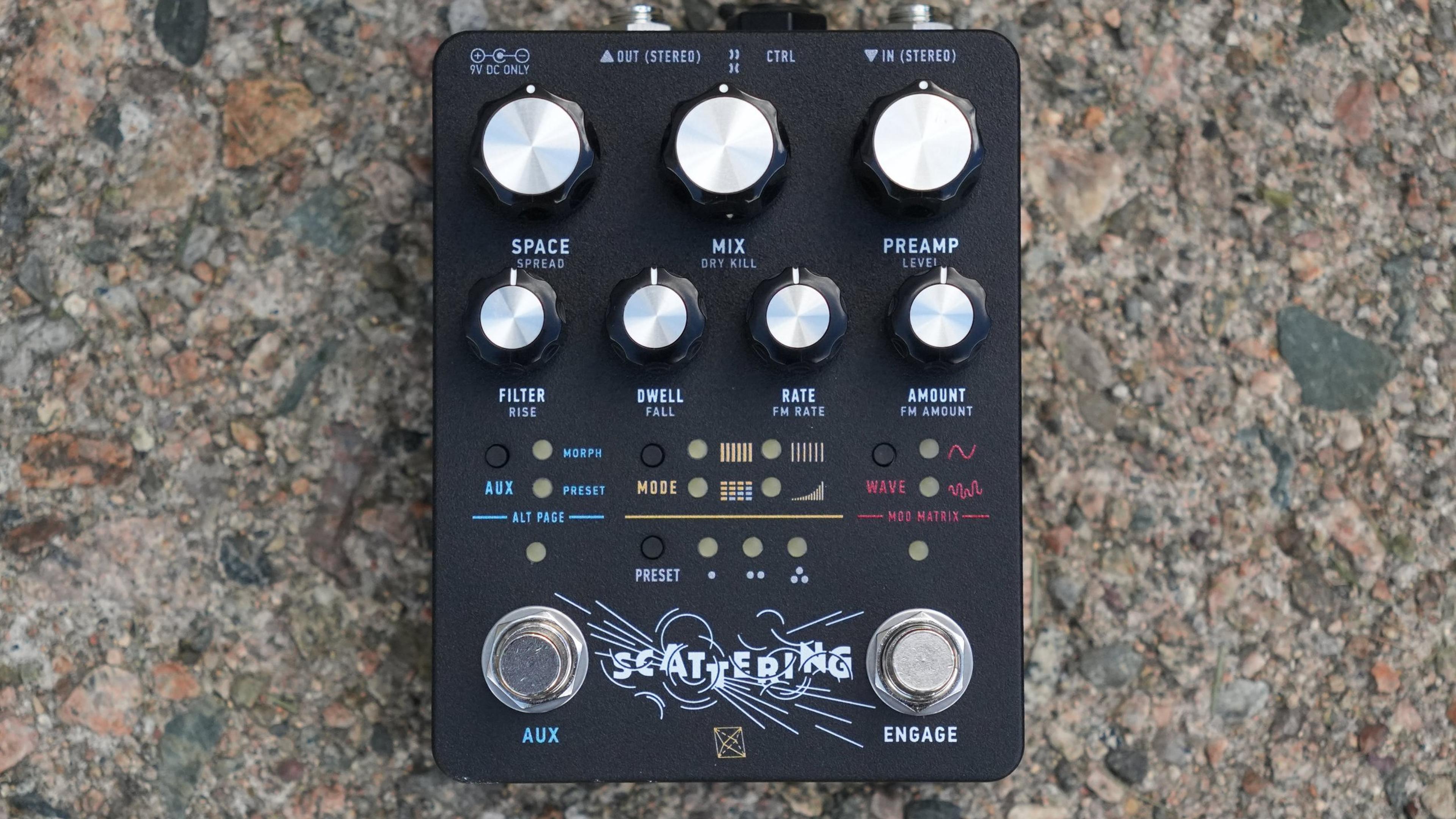 Electronic Audio Experiments Scattering pedal on gravel, top-down hero shot showing knobs, MODE WAVE buttons, and AUX ENGAGE footswitches