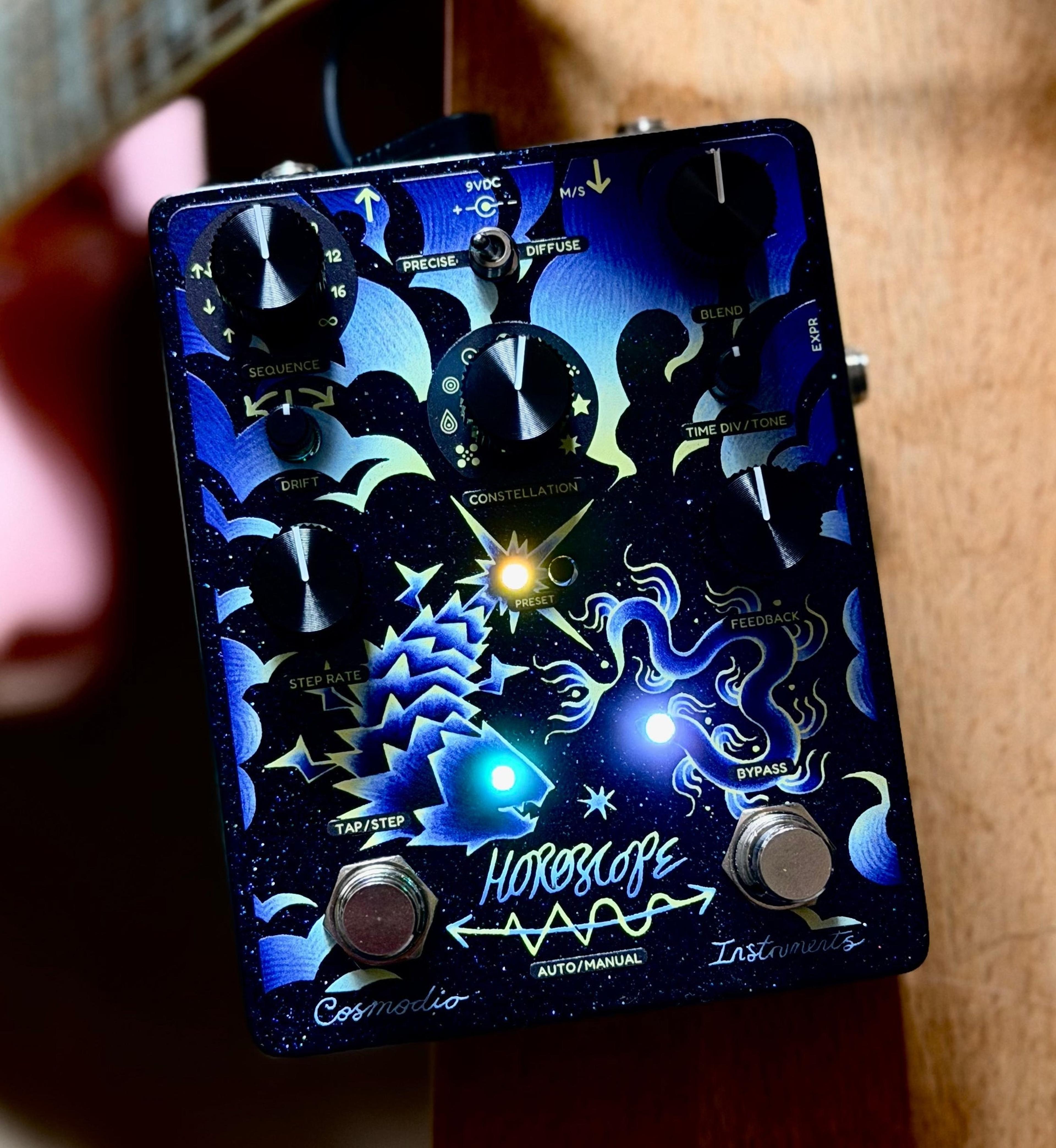 Cosmodio Horoscope leaning against a guitar neck on warm wood, preset and status LEDs lit