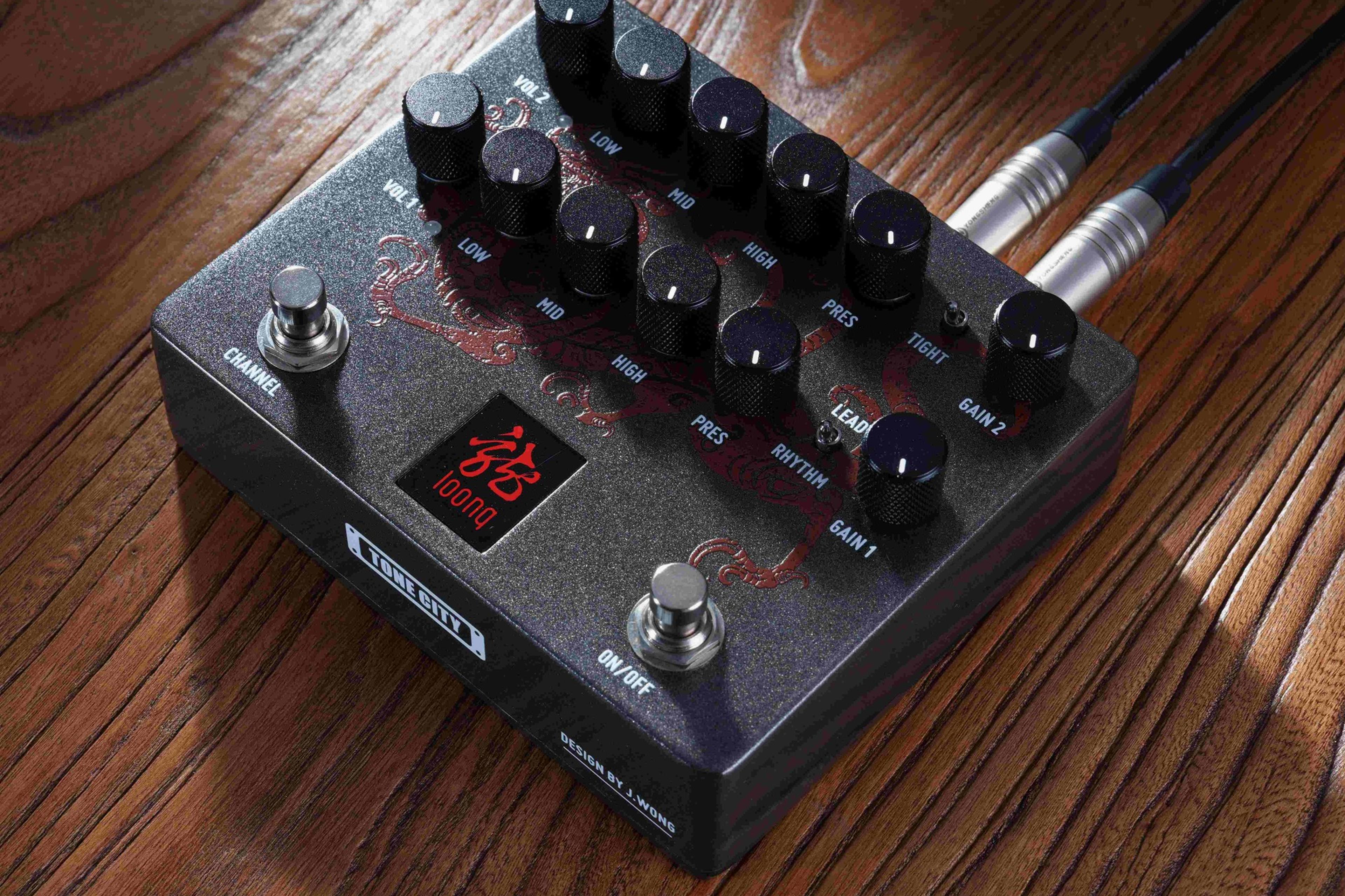 Tone City LOONG on a wooden surface with cables plugged into top jacks, dragon graphic lit