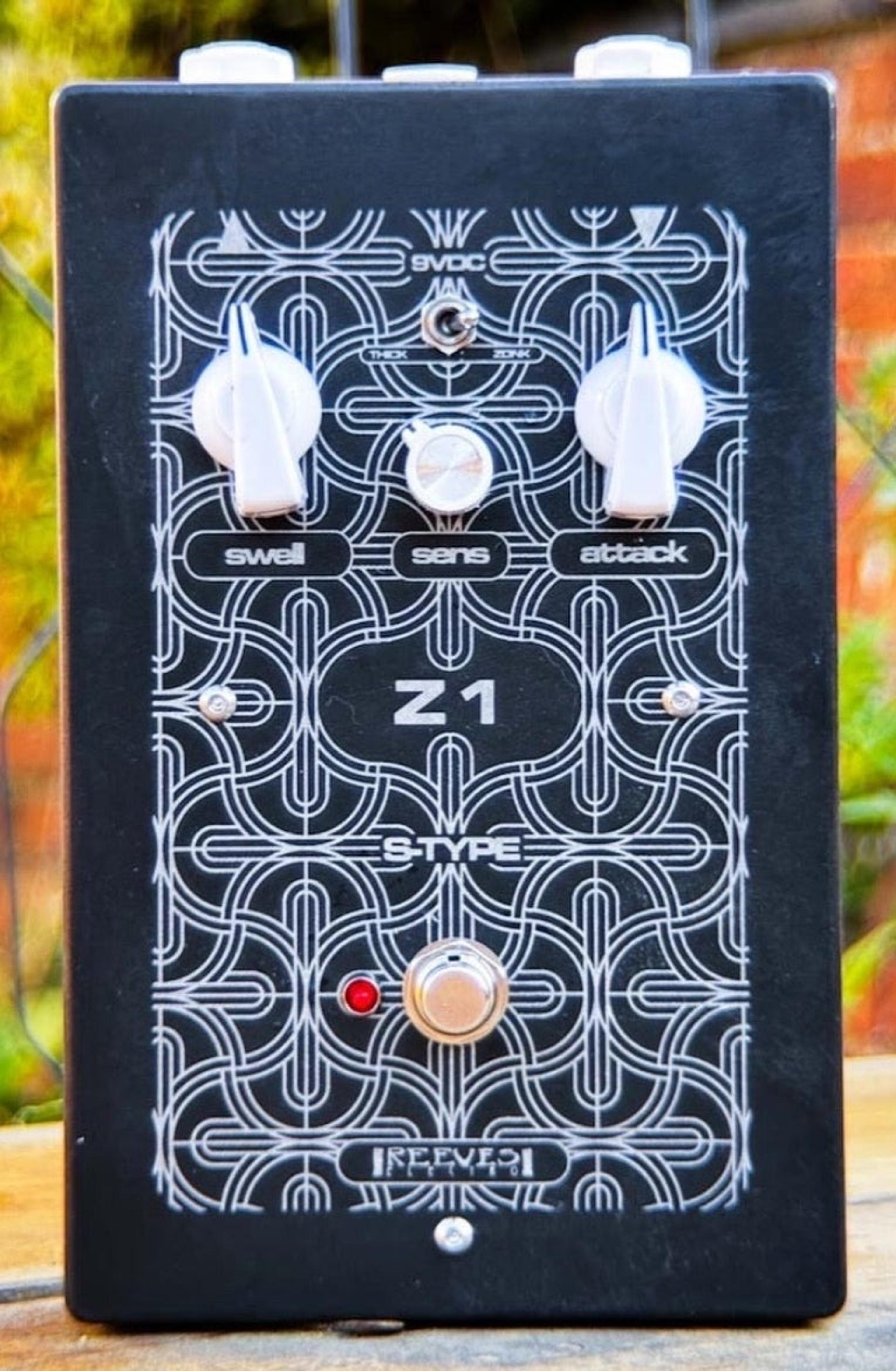 Reeves Electro Z1, front view, black acid-etched enclosure with Swell, Sens and Attack knobs, a Thick/Zonk toggle and a red LED