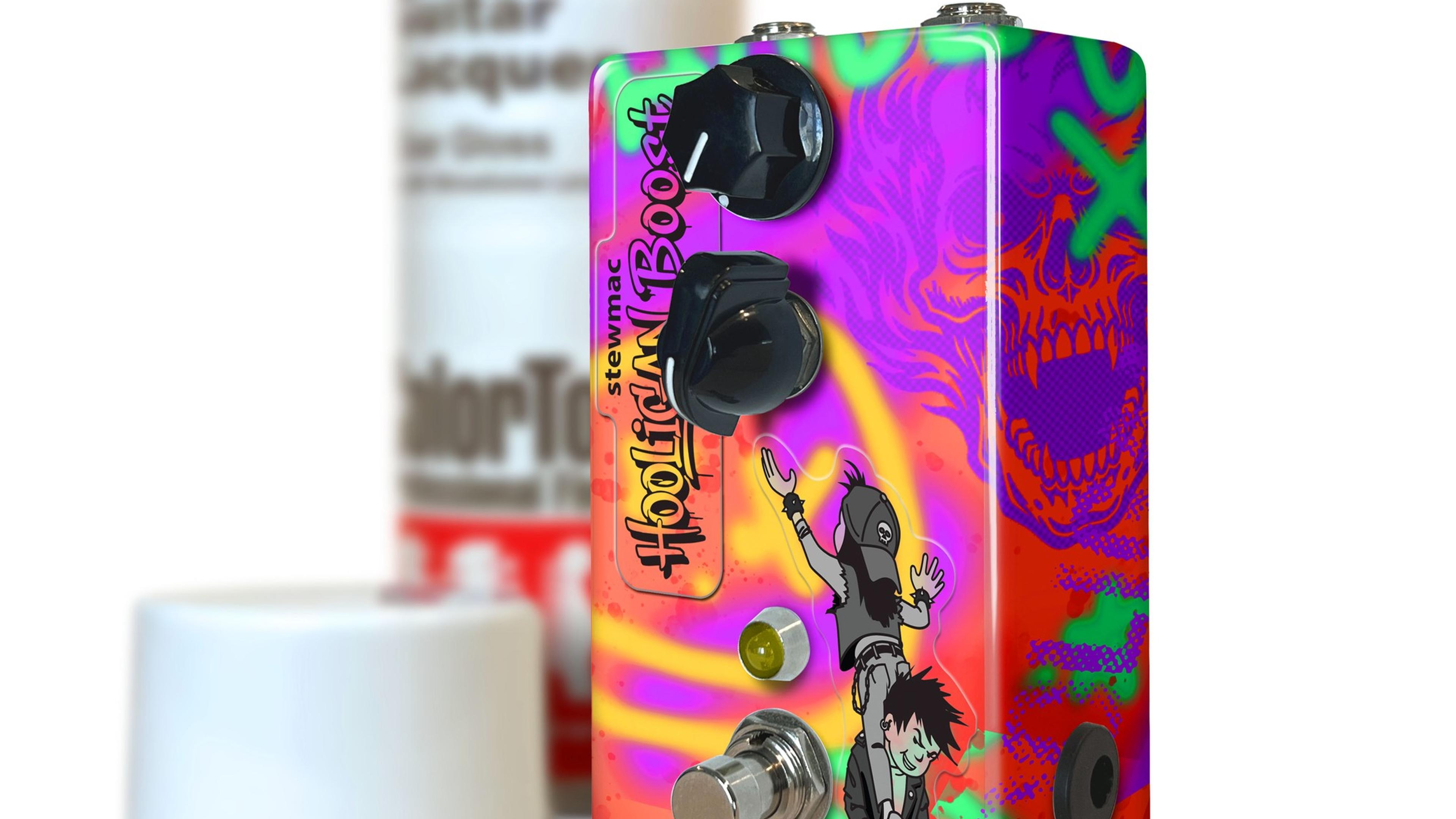 StewMac Hooligan Boost custom-painted enclosure next to a ColorTone spray can, graffiti graphics and skull side art