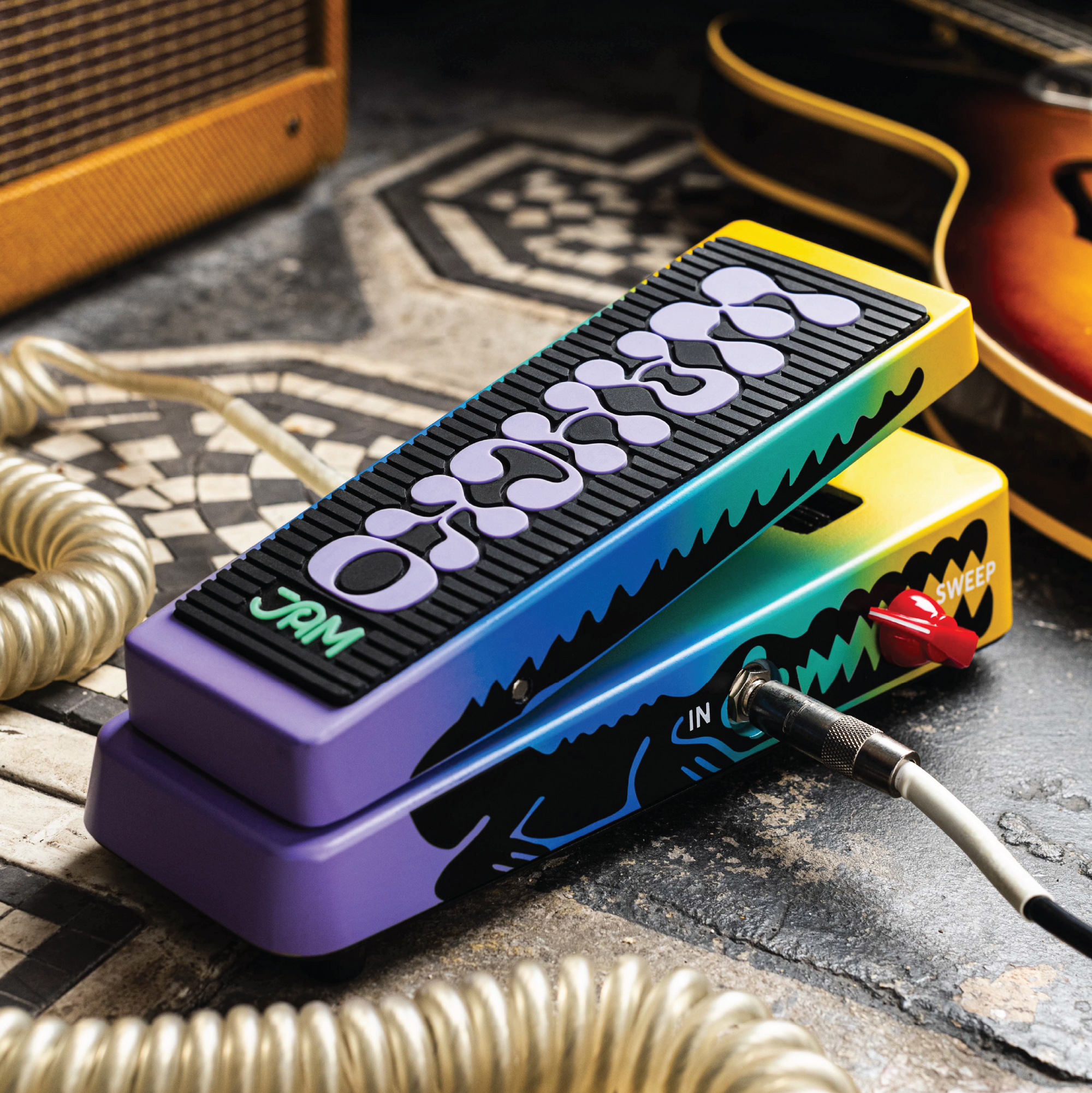 JAM Pedals Wahcko wah pedal on tiled floor with coiled cable, amp and sunburst guitar in frame