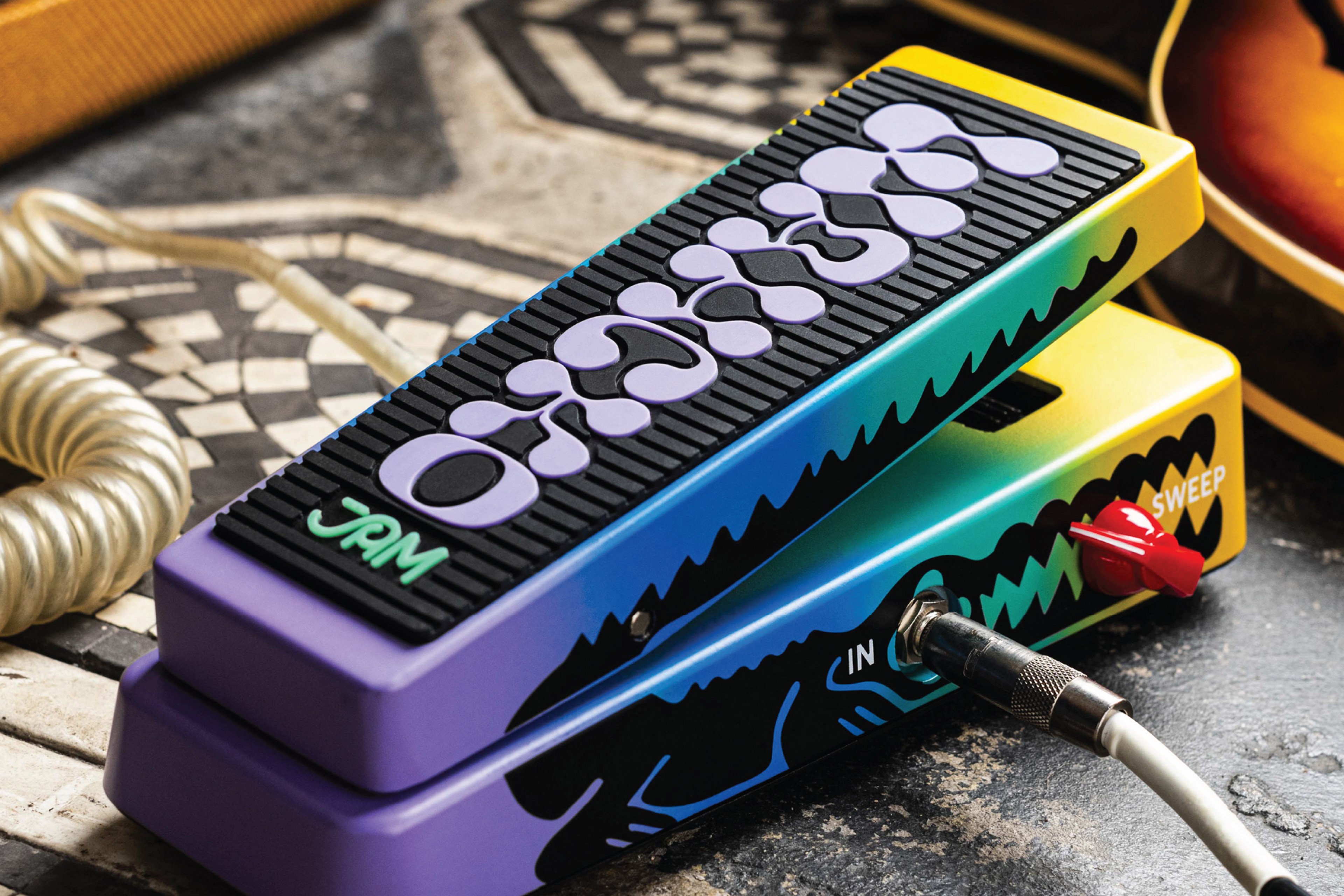 JAM Pedals Wahcko wah pedal on tiled floor with coiled cable, amp and sunburst guitar in frame
