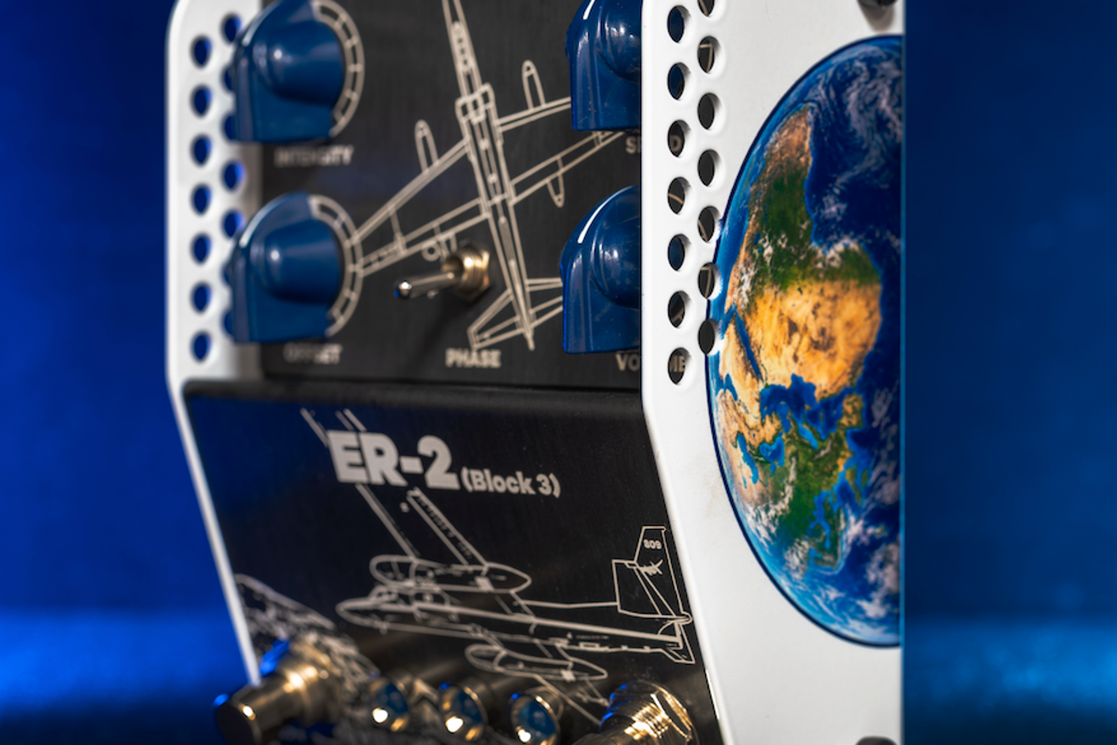 ThorpyFX ER-2 Block 3 seen from the side in blue light, black panel with blue knobs and aircraft line art, a Phase toggle and an Earth graphic on the white side panel