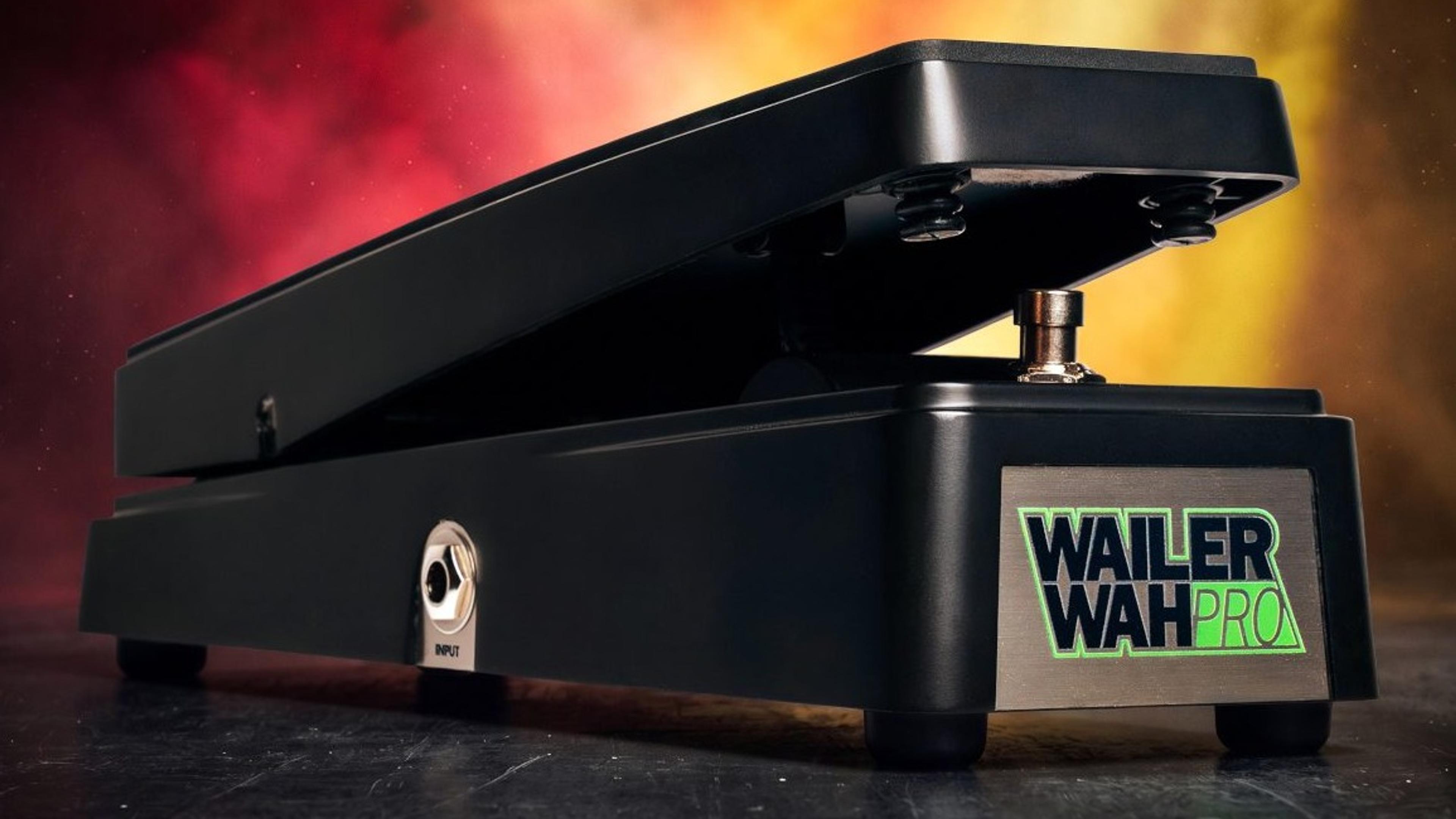 Electro-Harmonix Wailer Wah Pro on a dark stage floor in front of red and amber smoke, black die-cast treadle with the green Wailer Wah Pro nameplate