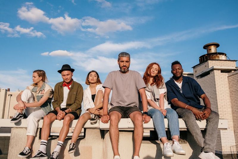 Group of friends sitting on a rooftop enjoying a warm summer day. Perfect depiction of togetherness and leisure.