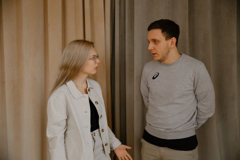 Man and woman having a serious conversation indoors, focused expressions.