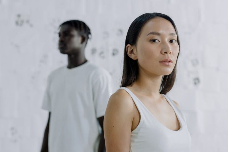 Portrait of diverse individuals in a minimalist studio setting, showcasing thoughtful expressions.
