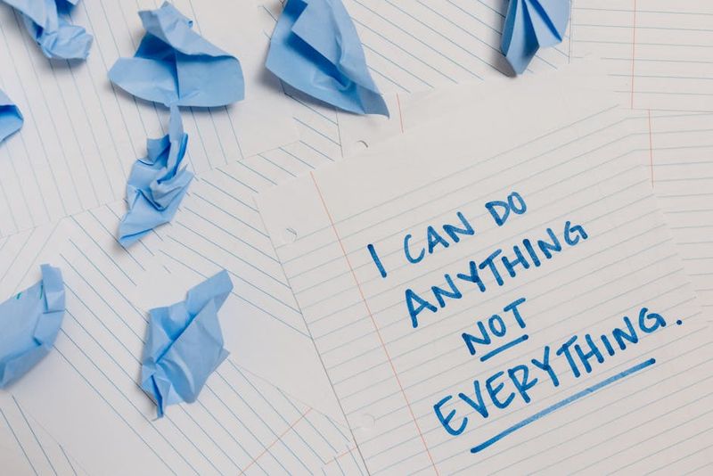 Inspirational quote on paper surrounded by crumpled blue sheets, conveying motivation.