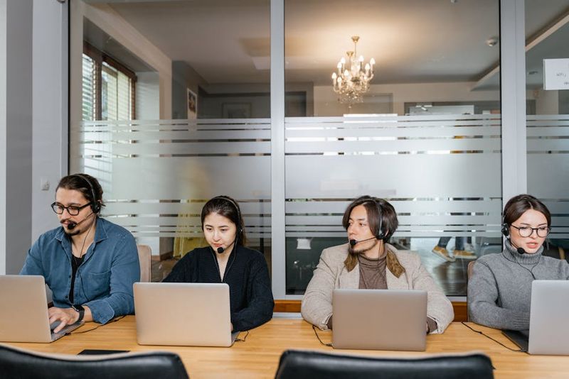Eine vielfältige Gruppe von Callcenter-Mitarbeitern arbeitet gemeinsam in einem modernen Büroumfeld.