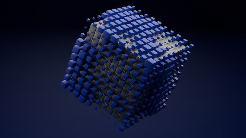 A 3D abstract cube made of blue blocks floating on a dark background.