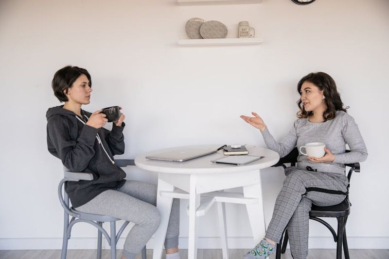 Zwei Frauen genießen ein ungezwungenes Gespräch bei Kaffee in einer gemütlichen Innenumgebung, was die Verbindung stärkt.
