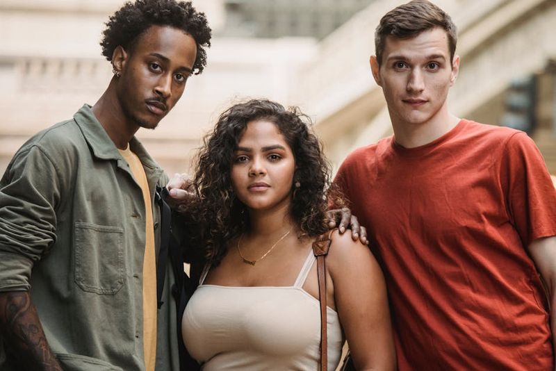 Three diverse friends confidently pose in an urban setting, showcasing friendship and individuality.