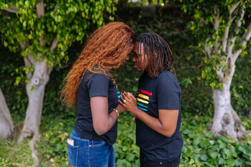 Two women lovingly stand together outdoors, embracing LGBTQ+ pride and unity.