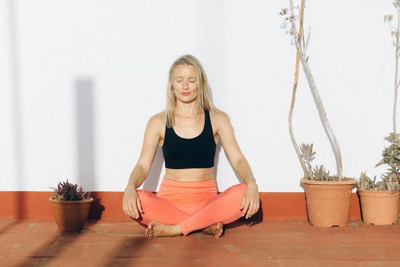 A woman meditating outdoors in activewear, enjoying mindfulness and relaxation.