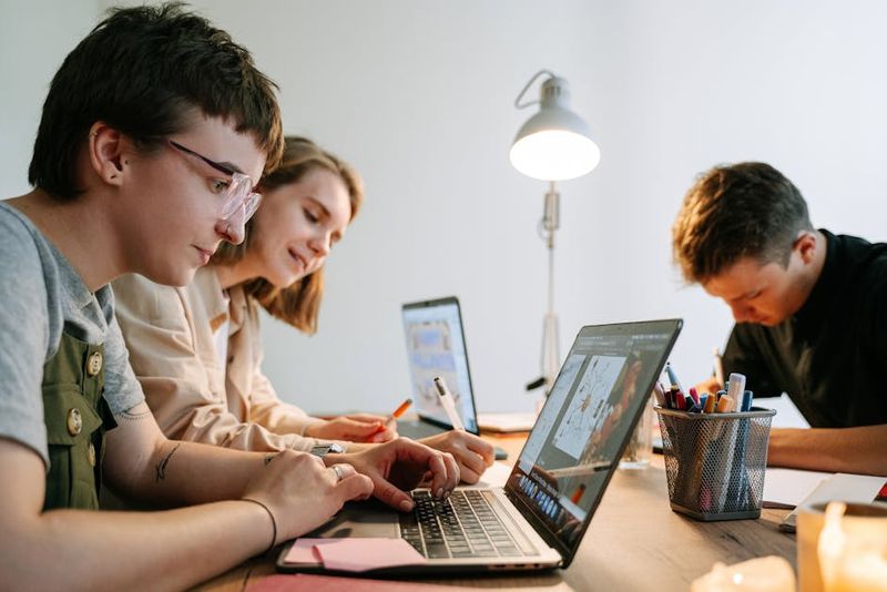 Young creative professionals collaborating on a project in a modern workspace. Perfect teamwork depiction.