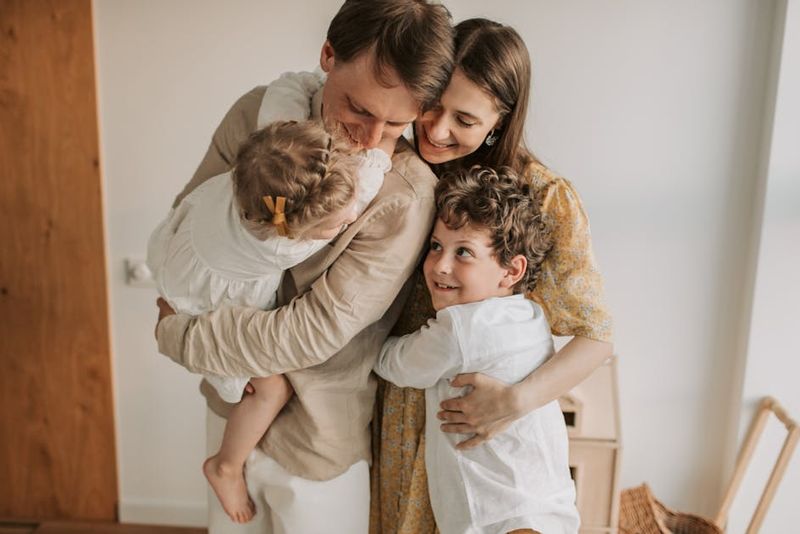 Una scena commovente di una famiglia che si abbraccia in casa, che mostra amore e unità.