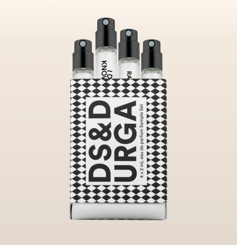 A set of four small perfume spray vials in a black-and-white checkered box labeled "DS&DURGA 4 x 2 ml Eau de Parfum Sample Set" against a light beige background.
