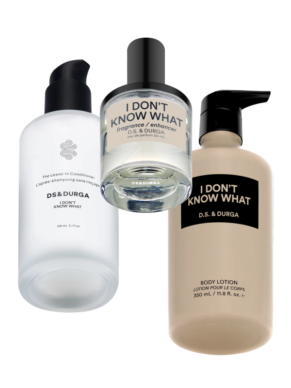 Three D.S. & Durga "I Don't Know What" products: a clear bottle of leave-in conditioner, a round bottle of fragrance enhancer, and a beige bottle of body lotion, all with black and white labels.