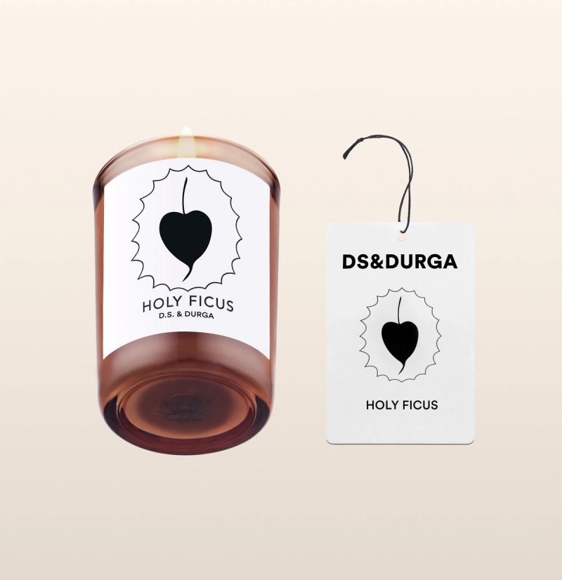 An elegant, lit scented candle by d.s. & durga with holu ficus fragrance, accompanied by a matching auto fragrance. 