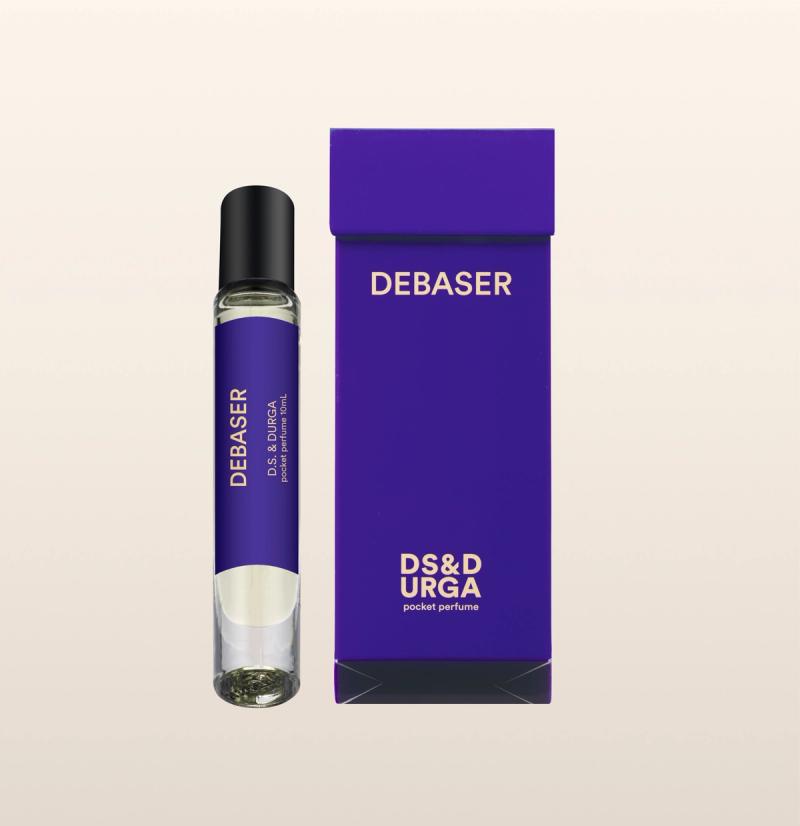 A sleek, roll-on bottle of "debaser" perfume oil, next to its minimalist packaging.