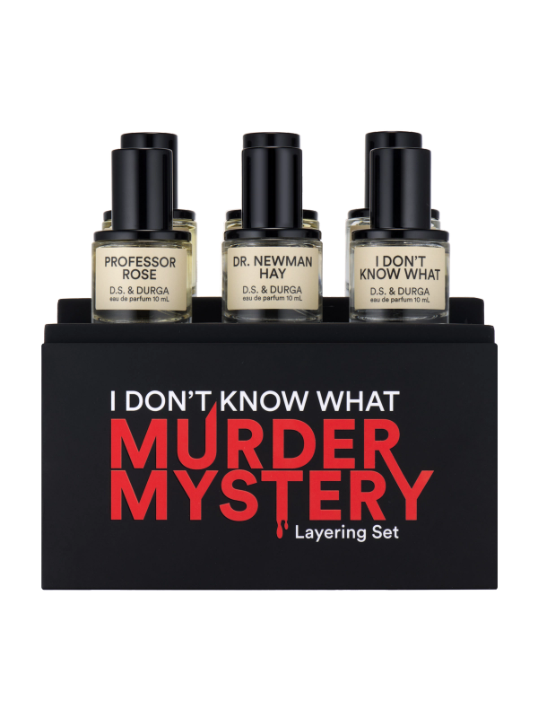 A perfume layering set in sleek black packaging with red and white text that reads "I DON'T KNOW WHAT MURDER MYSTERY." The set includes three bottles labeled "PROFESSOR ROSE," "DR. NEWMAN HAY" and "I DON'T KNOW WHAT.