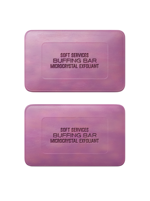 Two purple rectangular bars labeled "Soft Services Buffing Bar Microcrystal Exfoliant" are displayed on a light beige background. The bars appear smooth with slightly rounded edges and are positioned one above the other.