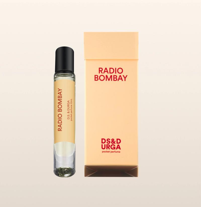 A sleek, roll-on bottle of "radio bombay" perfume oil, next to its minimalist packaging.