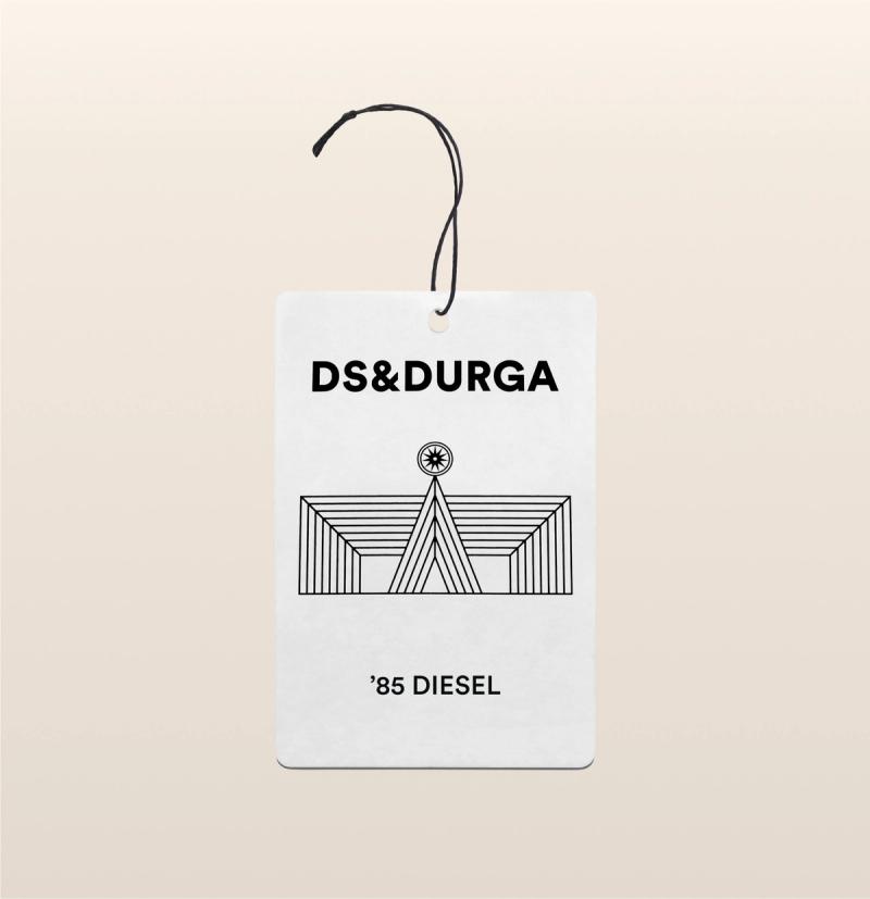 A hanging auto fragrance with the inscription "ds &amp; durga" and the scent name "85 diesel," adorned with an art deco style image.