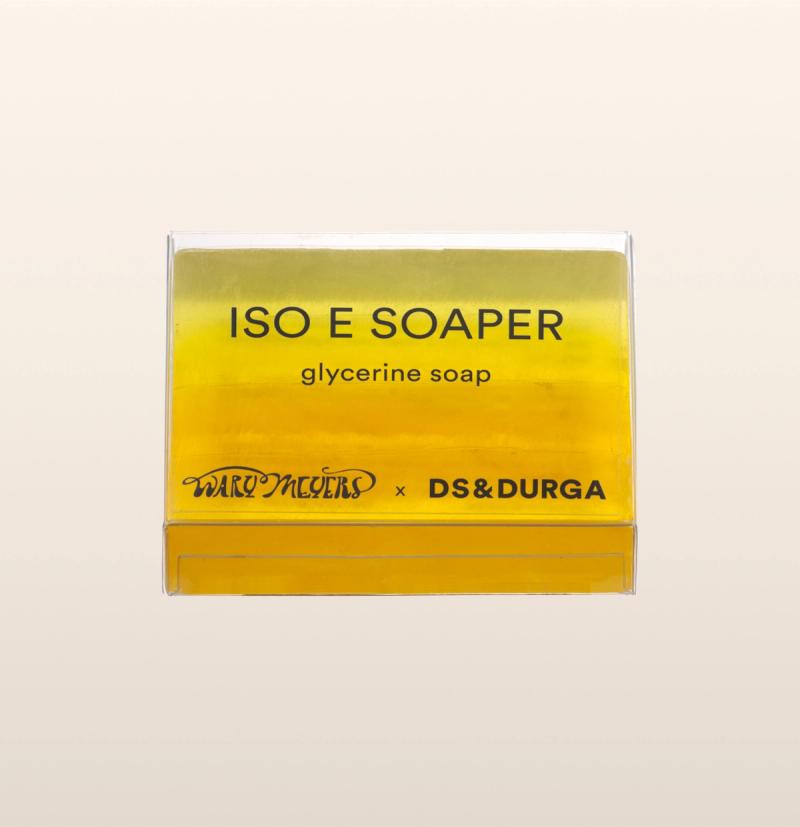 A bar of Iso E Soaper yellow glycerine soap in clear packaging that features collaboration branding Wary Meyers and D.S. & Durga.
