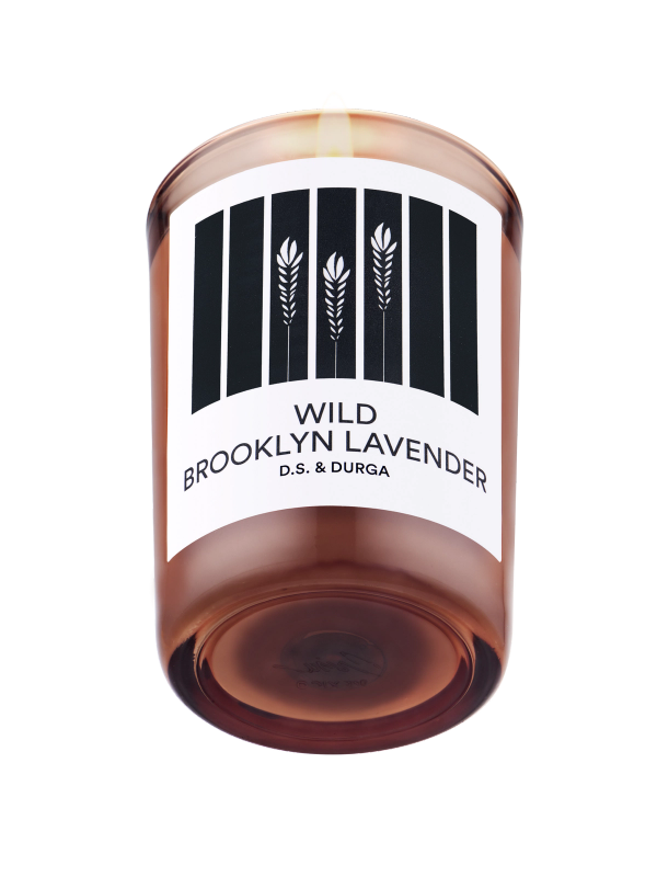 A lit scented candle with label reading "wild brooklyn lavender" by d.s. &amp; durga on a transparent background.