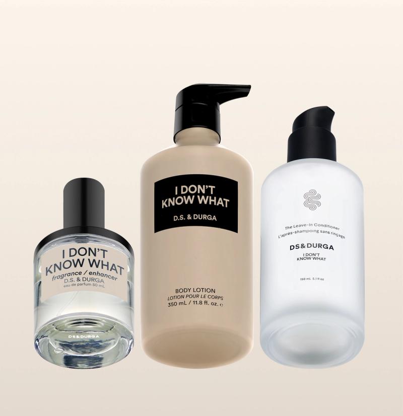 Three D.S. & DURGA products: a small bottle labeled "I DON'T KNOW WHAT" fragrance enhancer, a pump bottle of body lotion, and a clear pump bottle of leave-in conditioner, all on a light background.